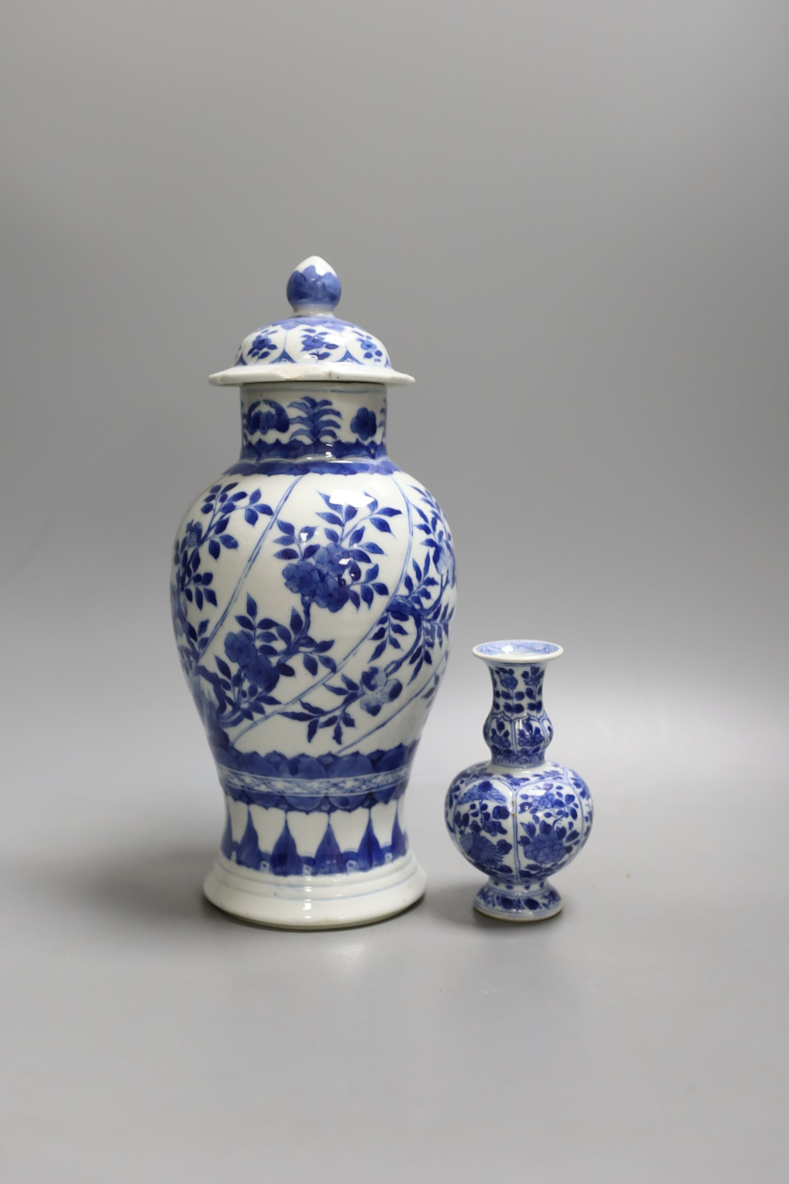 A Chinese blue and white vase and cover, Kangxi mark, 19th century, 26.5cm tall, and a Chinese Kangxi period small vase (2)